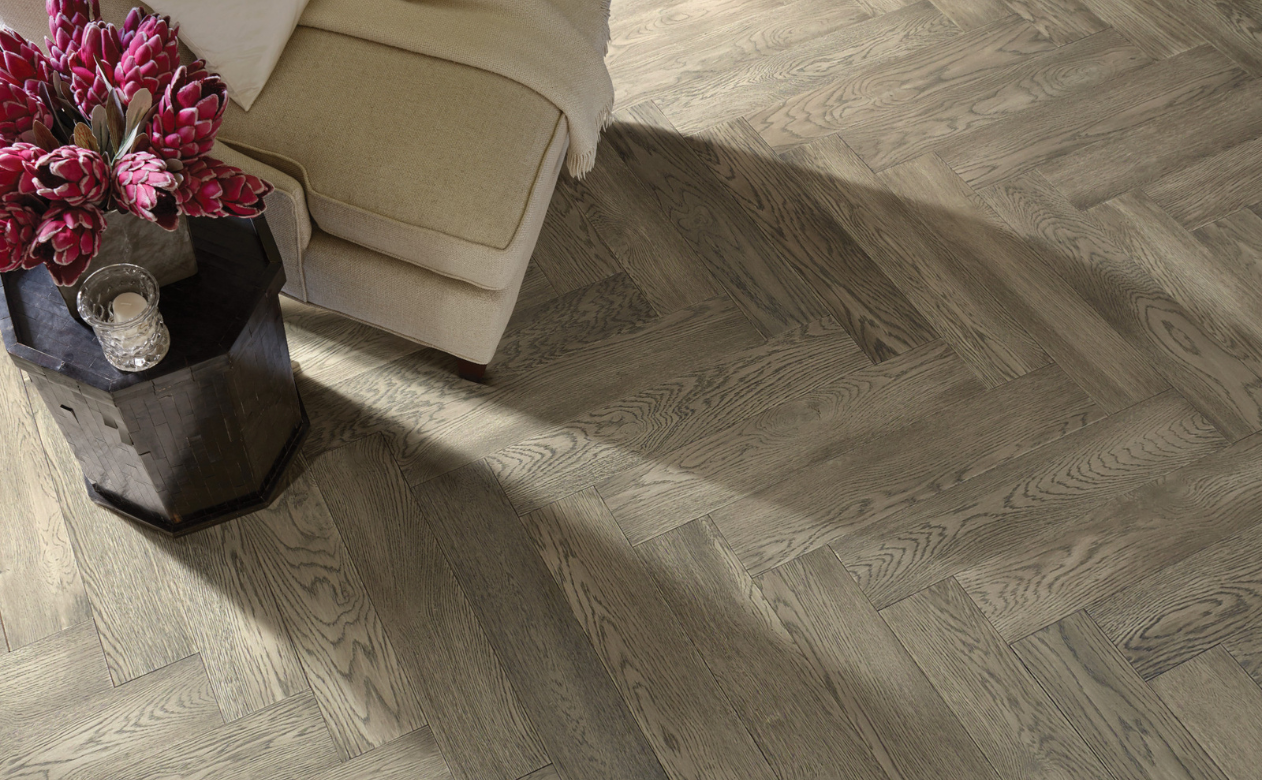 Herringbone hardwood floor with cream chair 